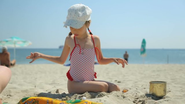 Woman and child playing with sand on beach