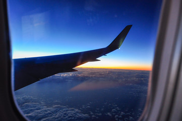 Photograph of the wing of an airplane from inside. Photo at sunrise with spectacular lighting.