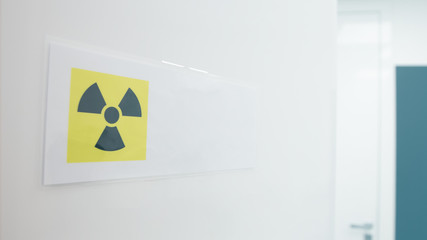CAUTION: X-RAY IN USE warning sign posted on open door to dental room.