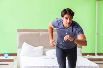 Young handsome man doing morning exercises in the hotel room