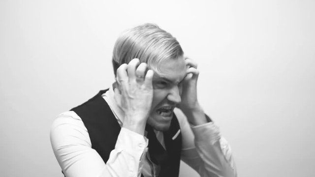 emotional portrait of a crazy guy in close-up. concept: the nervous breakdown, mental disease, headaches and migraine. black and white treatment