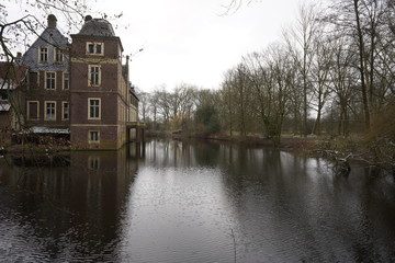 Wasserschloss am See, Teich, bedecktes Dach mit Schnee im Winter