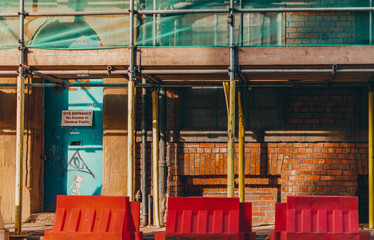 A blue door with a warning sign underneath some scaffolding in Sheffield, UK