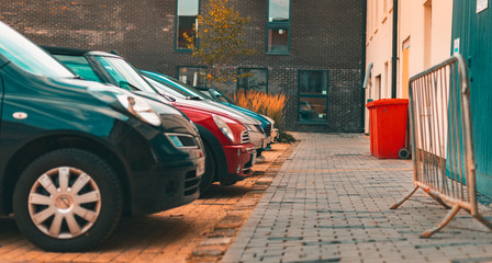 A selection of modern cars parked up against a new housing estate