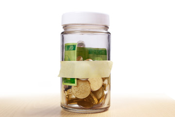 Coins in glass money jar savings with empty label, financial concept