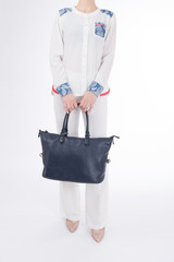  woman with blue handbag in hands. Isolated white background.