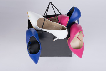  high-heeled stiletto shoe-filled shopping bag and overflowing on isolated background