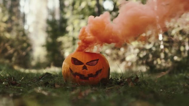 4k Footage Of Halloween Pumpkin With Orange Smoke Bomb