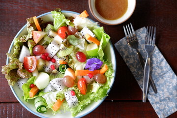 fruit salad and vegetable salad on wood table