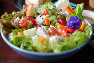 fruit salad and vegetable salad on wood table