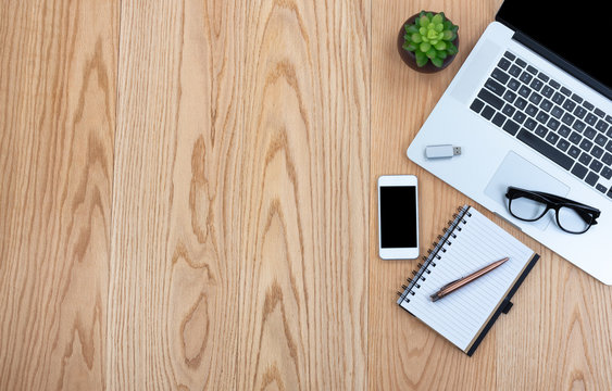 Wooden desktop with basic technology and stationery for work space