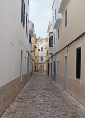 a typical narrow cobbled street of traditional painted houses in ciutadella menorca