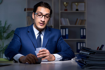 Young business playing cards late in office