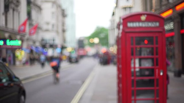 Defocused shot of traditional red telephone booth on urban street in London