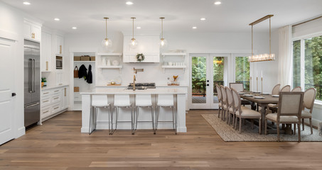 Beautiful kitchen and dining room panorama in new luxury home, with pendant lights, dining room...