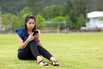 Young asian woman reading messages on her mobile phone