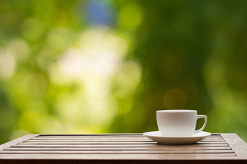 Coffee espresso on wood table nature background in garden,warm tone