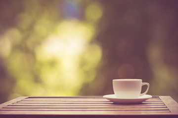 Coffee espresso on wood table nature background in garden,warm tone
