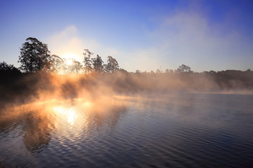 Sun light through trees in misty morning Kandawgyi Lake, Myanmar