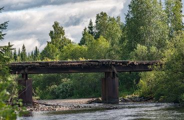 Dilapidated bridge across the river Uls