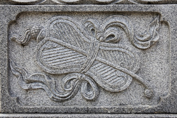 The object of the granite carving is a a palm-leaf fan (plantain fan) which symbolizes wisdom in Chinese Culture. 