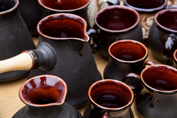 Clay jezve with wooden handle and coffee cups