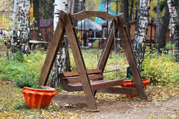 Fototapeta na wymiar Large wooden swing in the the garden