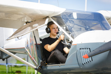 outdoor shot of young man in small plane cockpit