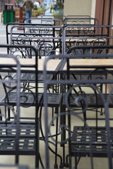 Street View of Empty Café Tables and Chairs, Against Out of Focus Mall Background