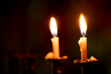 Candles burning in the dark night  with focus on single candle in foreground