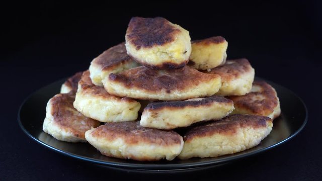 Potato cakes, ukrainian name potato zrazy, stuffed mushrooms or meat or cheese with herbs cream are fried in vegetable oil on black background, close up, rotates. Traditional Ukrainian cuisine