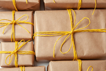 Gift boxes in festive packaging with golden yellow bows. Delivery of gifts by the postal cargo service. Concept of New Year, birthday, valentine's day, holiday