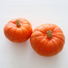 Halloween holiday minimal top view image of pumpkin over white wooden background.