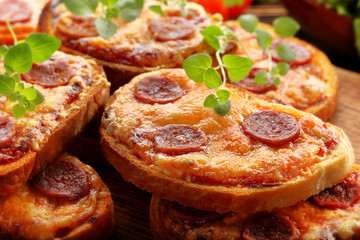 Toasts with melted cheese and fried sausage, breakfast on wooden background