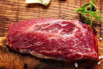 Raw slices beef steak on wooden background