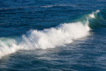 Shallow wave breaking on the beach shore.