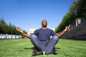 man sitting on the grass and looking at camera