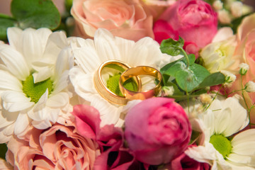 Wedding Rings on beautiful natural flowers bouquet