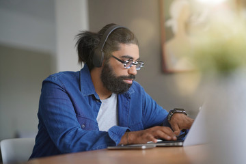 Obraz premium Hipster guy using smartphone and bluetooth headset