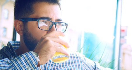Arabic Egyptian young business attractive man having a coffee break and drinking orange juice in...