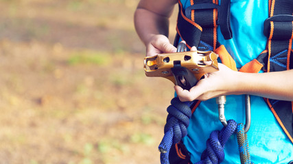 Cute little boy in blue shirt and helmet having fun at the adventure park, holding ropes and prepering to climb wooden stairs. Hobby, active lifestyle concept.