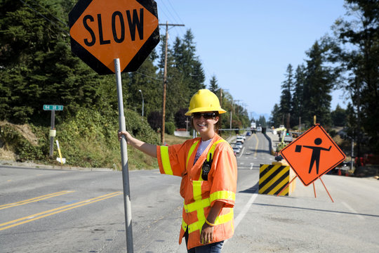 construction worker with stop sign on road