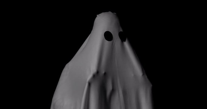 White ghost standing on black background. Concept for funny costume in halloween festival.