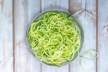 Courgette spaghetti - shredded zucchini on a plate - top view