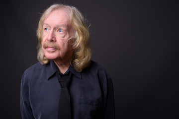 Senior businessman with mustache against gray background