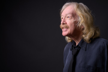 Senior businessman with mustache against gray background