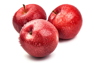 Shiny Red ripe apples with water drops, isolated on white background. Fresh raw organic fruits. Close-up.