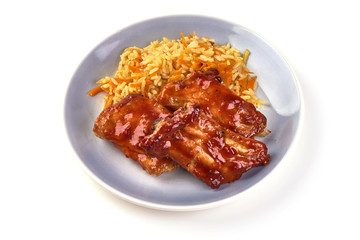 Delicious spicy marinated ribs in a bbq or tomato sauce with rice, isolated on a white background