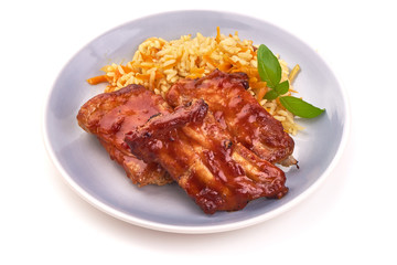 Delicious spicy marinated ribs in a bbq or tomato sauce with rice, isolated on a white background.