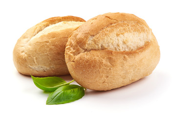 Freshly baked crispy bread rolls with basil leaves, close-up, isolated on a white background